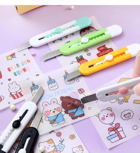 Primer plano de mini cúteres de colores sobre bonitas pegatinas de papelería de dibujos