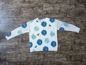 White bohemian V-neck sweater with blue floral prints and elegant crochet lace sleeves.
