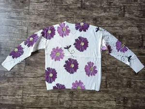 White Bohemian floral knit sweater with V-neck and elegant hollow-out crochet sleeves.