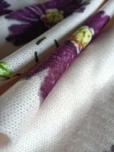 Detailed macro shot of bohemian floral print on high-quality knit sweater fabric.