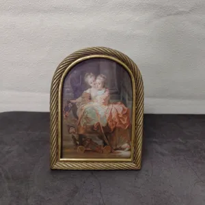 Close-up of vintage gold arched resin frame with intricate twisted rope border design