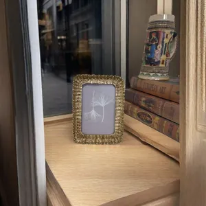 Gros plan sur un magnifique cadre photo decoratif dore en resin pour votre bureau.