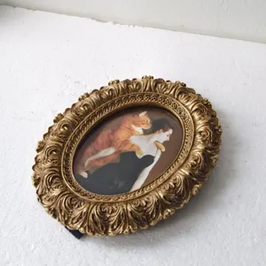 French vintage distressed gold oval embossed picture frame with funny cat and noblewoman portrait.