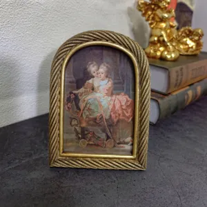 Detail of a vintage European arched gold photo frame with a classic twisted rope border