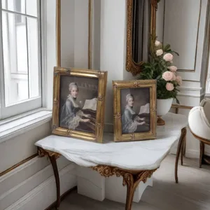 Detailansicht antiker goldener Vintage-Fotorahmen mit klassischen Ölgemäldedrucken auf Marmortisch.