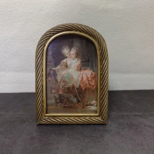 Detailed view of a vintage European arch-shaped gold resin frame with twisted rope border