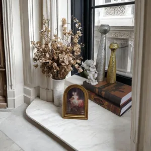 Dettaglio di una cornice per foto in resina dorata ad arco in un elegante interno