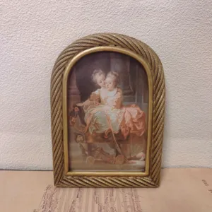 Macro detail of a vintage gold arched resin photo frame with twisted rope edge texture