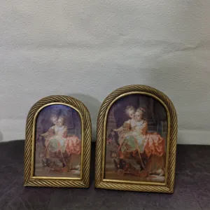 Pair of vintage gold arched resin picture frames with twisted rope border design.