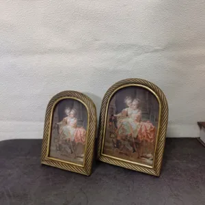 Detailed view of vintage European arched gold picture frames with elegant twisted rope edge design.