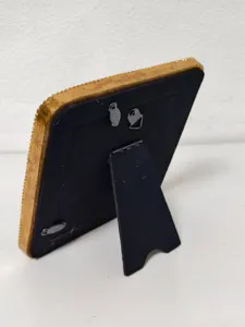 Back view of vintage gold relief picture frame showing stand and hanging hardware