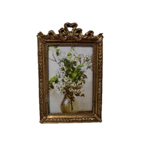 Cornice per foto dorata vintage con fiocco e stampa d'arte floreale per decorazioni.