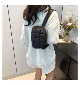 Vista trasera de modelo con un bolso de pecho acolchado negro en escena interior