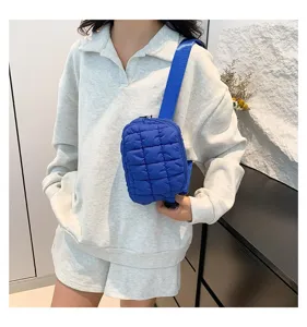 Modelo luciendo un bolso de pecho azul acolchado con un conjunto informal de verano