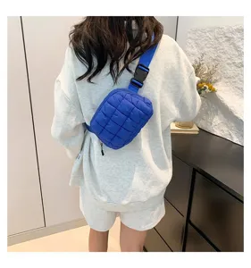 Vista trasera de una modelo con un pequeño y elegante bolso de pecho acolchado azul en el interior