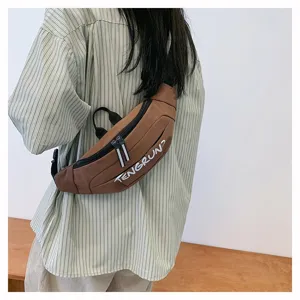 Rückansicht eines Modells mit einer braunen minimalistischen Nylon-Umhängetasche