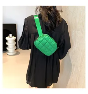 Detalle de vista posterior de un bolso de pecho acolchado verde usado como riñonera