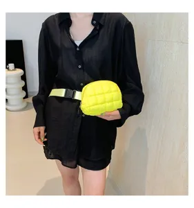 Modelo con un bolso de pecho acolchado amarillo neón vibrante sobre una camisa negra.
