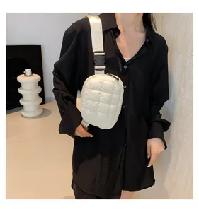 Vista detallada de un elegante bolso de pecho acolchado blanco para mujer con camisa negra