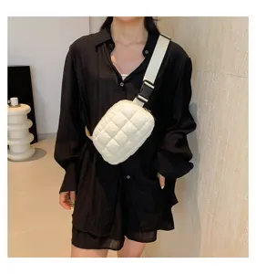 Elegante bolso de pecho acolchado crema usado por una modelo en un entorno de interior