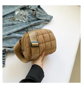 Primer plano de un elegante bolso de pecho acolchado caqui con correa tejida ajustable