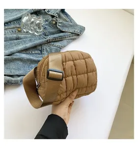 Detalle de bolso bandolera acolchado marrón con correa ancha ajustable y textura suave