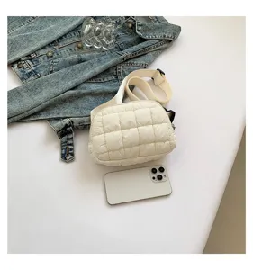 Elegante bolso de pecho acolchado blanco con chaqueta vaquera y móvil para referencia