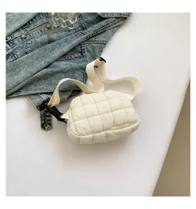 Vista detallada de un elegante bolso de pecho acolchado blanco con chaqueta vaquera