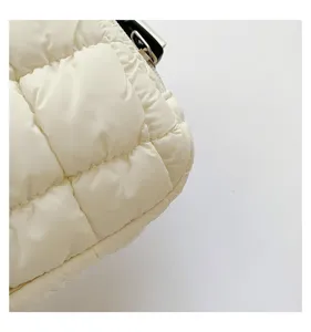 Detalle de un bolso de pecho acolchado blanco con costuras finas y textura brillante