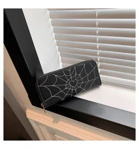 Close-up view of a black long wallet featuring unique heart and spiderweb print.