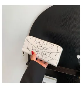 Close-up detail of a white women's long wallet featuring a spider web and heart print
