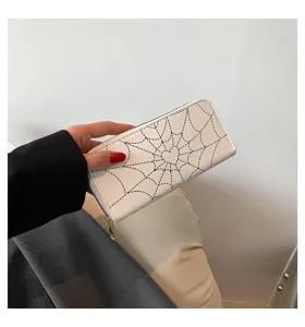 Close-up detail of white long zipper wallet featuring black spider web and heart print