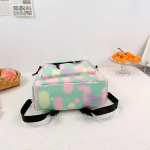 Detail macro view of a colorful pastel canvas backpack with star and heart patterns.