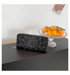 Close-up of black leather-style long wallet featuring unique white spider web print