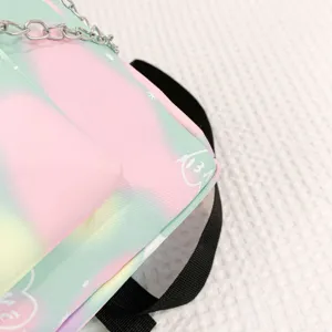 Close-up of a pastel gradient school backpack featuring chain detail and printed patterns