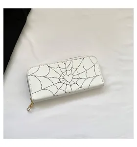 Detailed view of white women's long wallet with black spider web and heart pattern