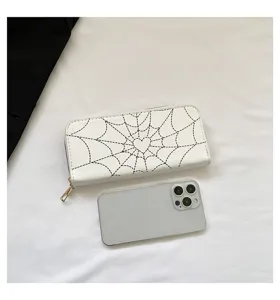 White long zipper wallet with spiderweb print shown next to a smartphone