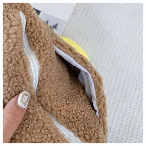 Detailansicht des Reißverschlusses einer braunen Plüschtasche mit weichem Innenfutter.
