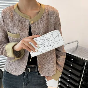 Stylish women's white long zipper wallet featuring black spider web print and heart detail