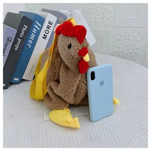 Detail einer süßen Plüsch-Hähnchen-Umhängetasche mit Smartphone als Größenreferenz