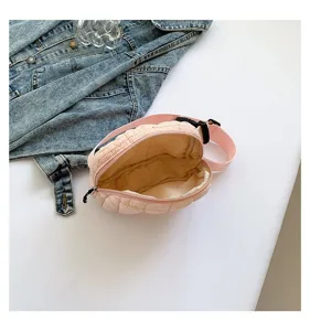 Primer plano de un bolso de pecho rosa acolchado que muestra el forro y el cierre de cremallera