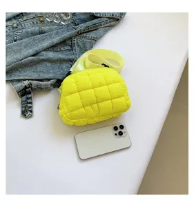 Riñonera acolchada en color amarillo vibrante junto a un smartphone como referencia de tamaño
