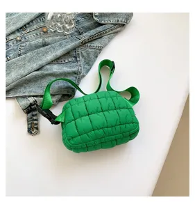 Detalle de una riñonera acolchada verde brillante con una chaqueta vaquera de fondo