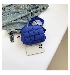Primer plano de un bolso de pecho acolchado azul que muestra su textura y tamaño