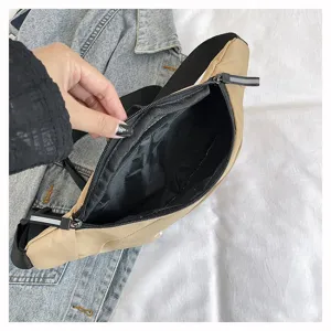 Detailansicht des geräumigen schwarzen Innenlebens und Reißverschlusses der khakifarbenen Tasche.