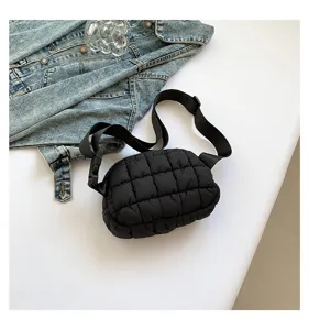 Primer plano de un bolso de pecho acolchado negro con correa ancha ajustable.