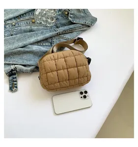 Bolso de pecho acolchado marrón con smartphone para referencia de tamaño en chaqueta denim.
