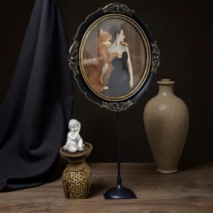 Cadre ovale vintage en résine noire avec détails dorés sur un support élégant