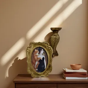 Marco de fotos de resina dorada tallada de estilo vintage europeo sobre una cómoda de madera