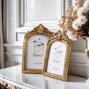 Vintage gold photo frame set with ornate carved arch design, elegant tabletop decor display.
